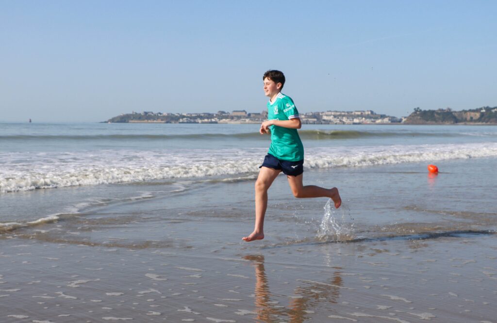 Jeune garçon courant dans l'eau