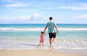 Père et fils marchant sur la plage