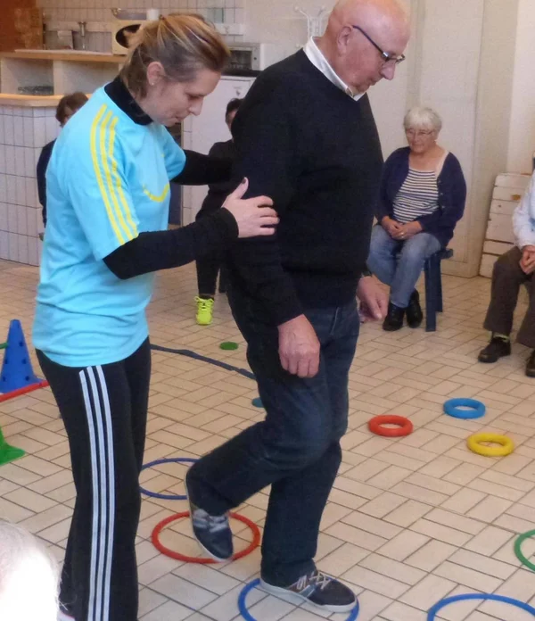 Exercice adapté avec des cerceaux au sol pour seniors