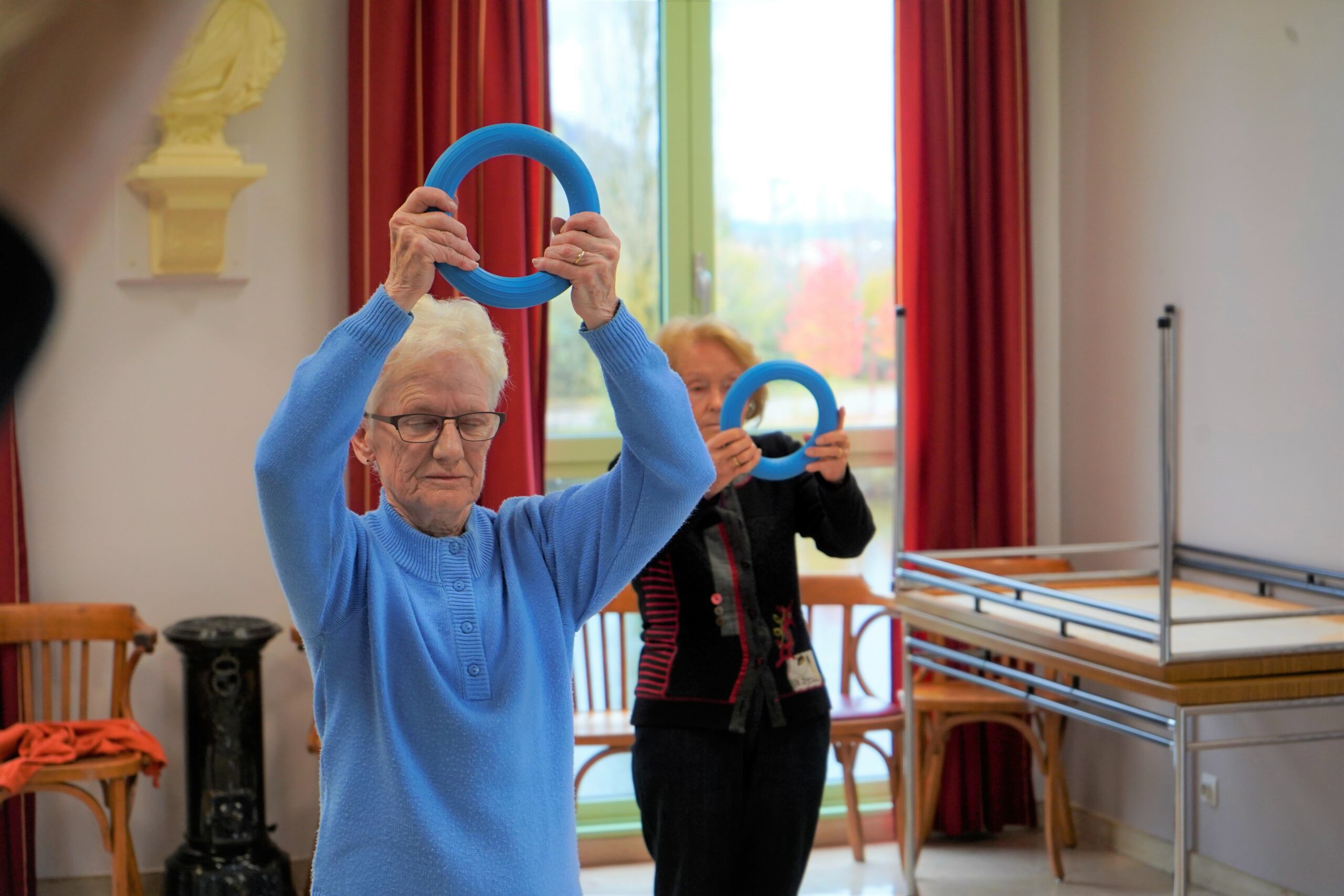 Deux seniors entrain de faire des exercices avec les anneaux adaptés