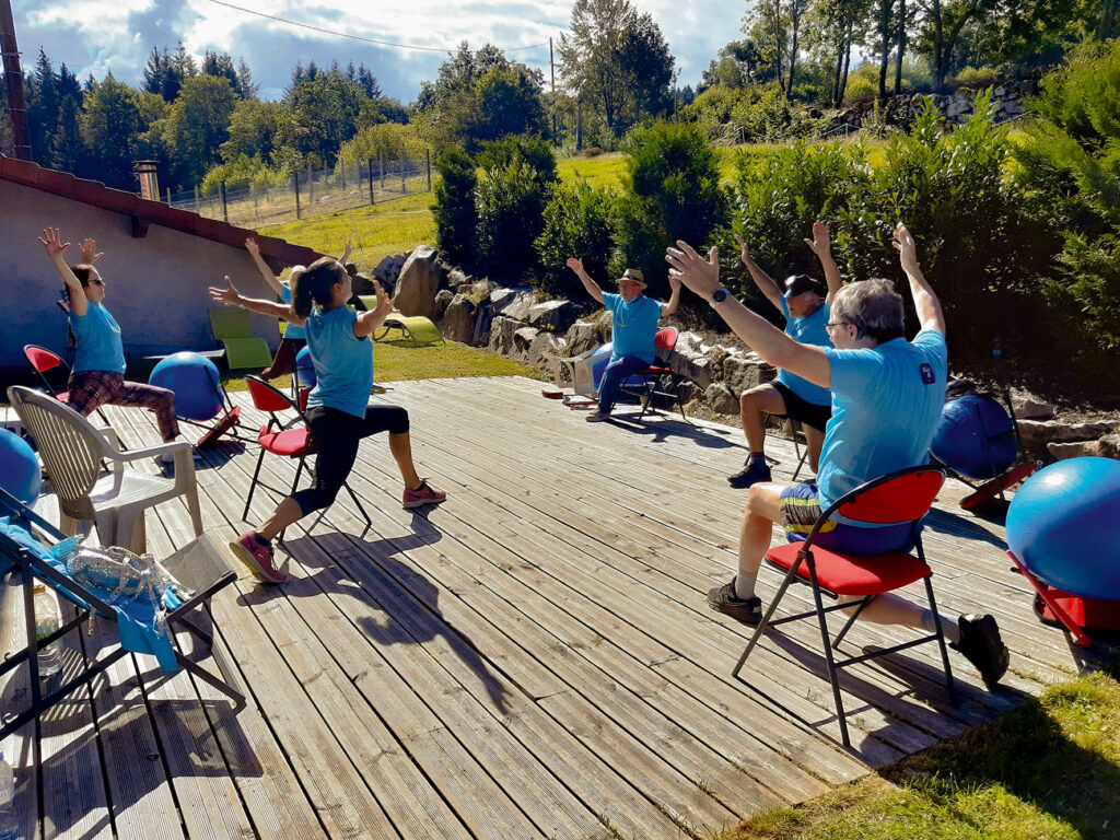 Groupe d'adulte entrain de faire de la mobilité sur une terrasse ensoleillée